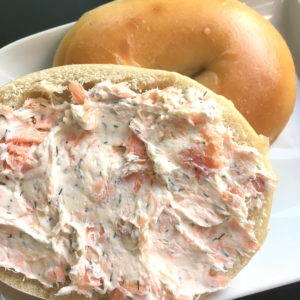 bagel with smoked salmon spread with dill closeup sq